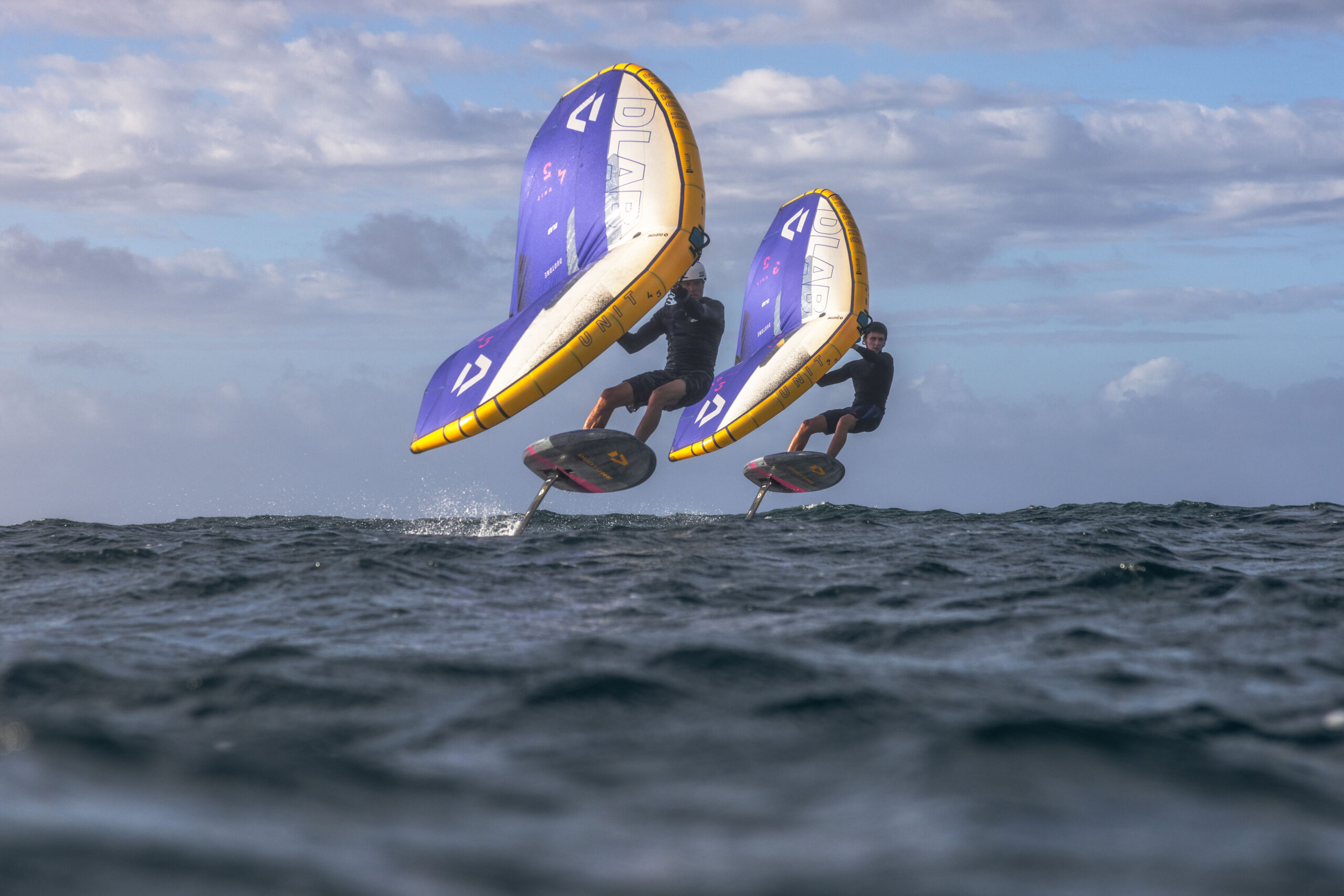 Op deze foto zie je duidelijk hoe twee wingfoilers uit het water komen met hun wing.